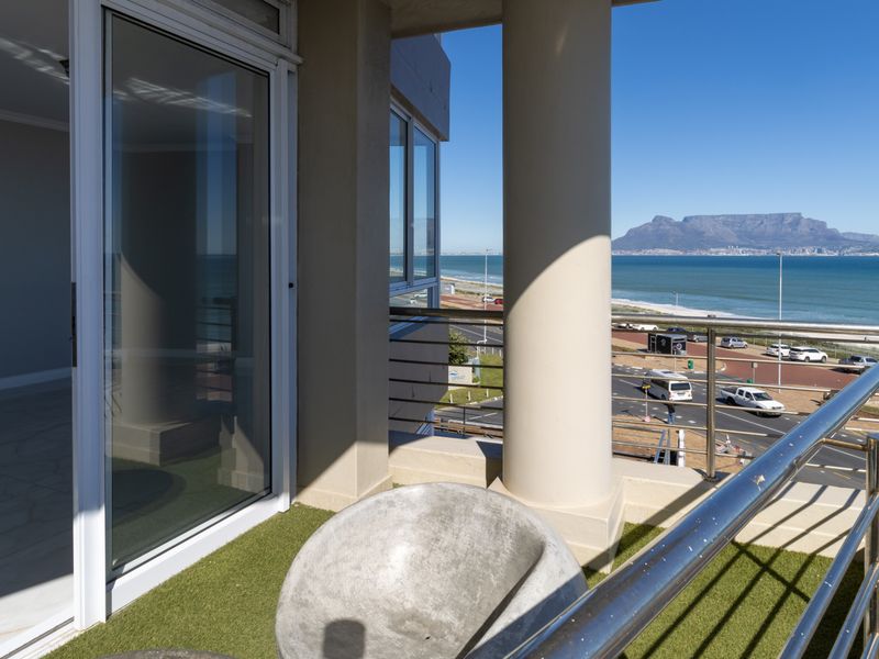 Spacious balcony featuring artificial turf, stainless steel railings, and panoramic views of the coastline and Table Mountain.