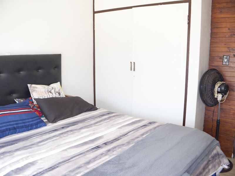 A bedroom featuring a built-in wardrobe and a decorative timber-paneled wall section.