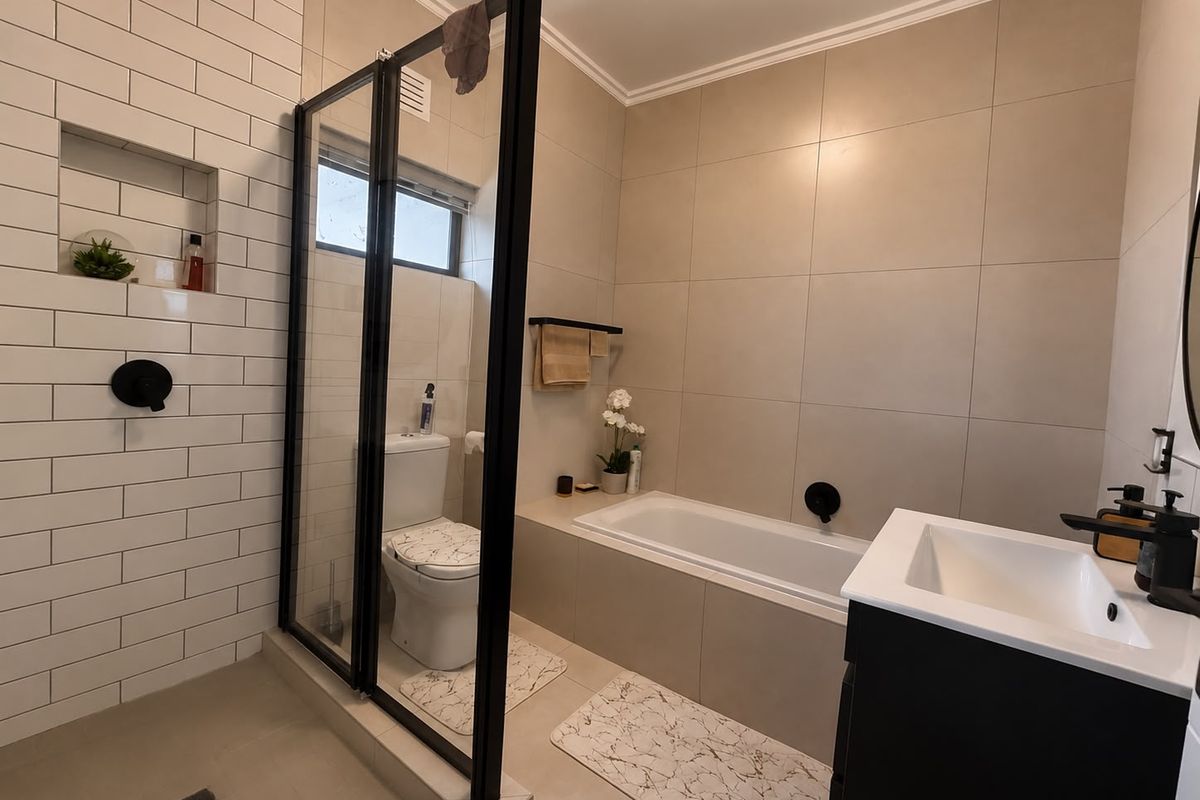 Modern bathroom featuring a glass-enclosed shower, built-in bathtub, contemporary vanity, and stylish subway tile accents.
