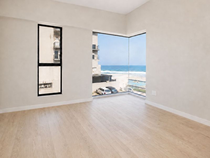 A bright, empty bedroom featuring modern laminate flooring, clean neutral walls, and a striking corner window offering expansive ocean views.