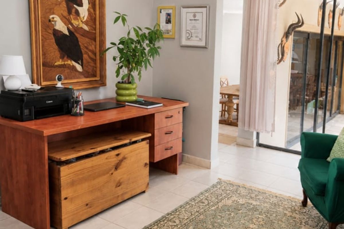 A bright living area featuring tiled flooring, recessed downlights, and a large sliding glass door providing access to an outdoor patio space.