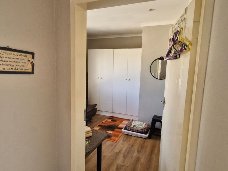 A bedroom featuring built-in cupboards and laminate flooring, viewed from the doorway.