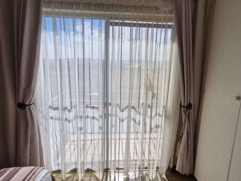 Bedroom featuring a sliding glass door with access to an outdoor area and built-in wardrobe storage.