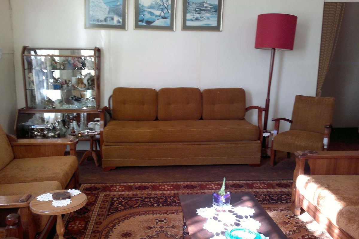 A traditional living room space featuring neutral wall finishes and carpeted flooring, suitable for modernization and updated interior design.