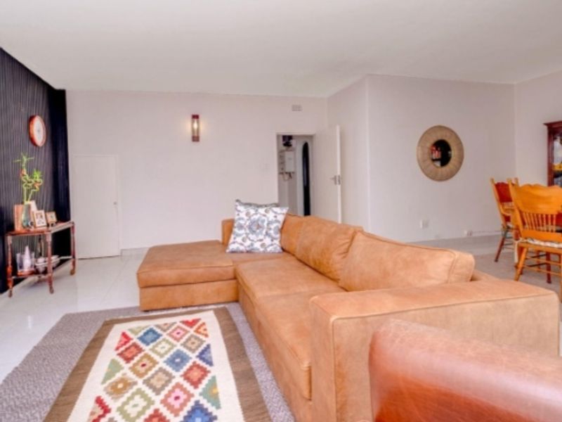 An open-plan living and dining area featuring tiled flooring and neutral wall finishes, providing a versatile space for relaxation and entertaining.