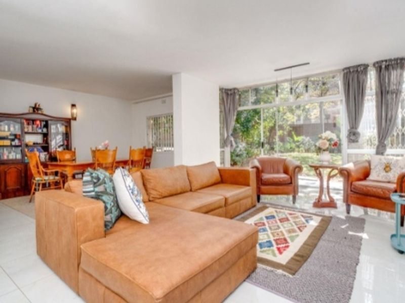 Spacious open-plan living and dining area featuring large glass sliding doors that provide ample natural light and access to the garden.