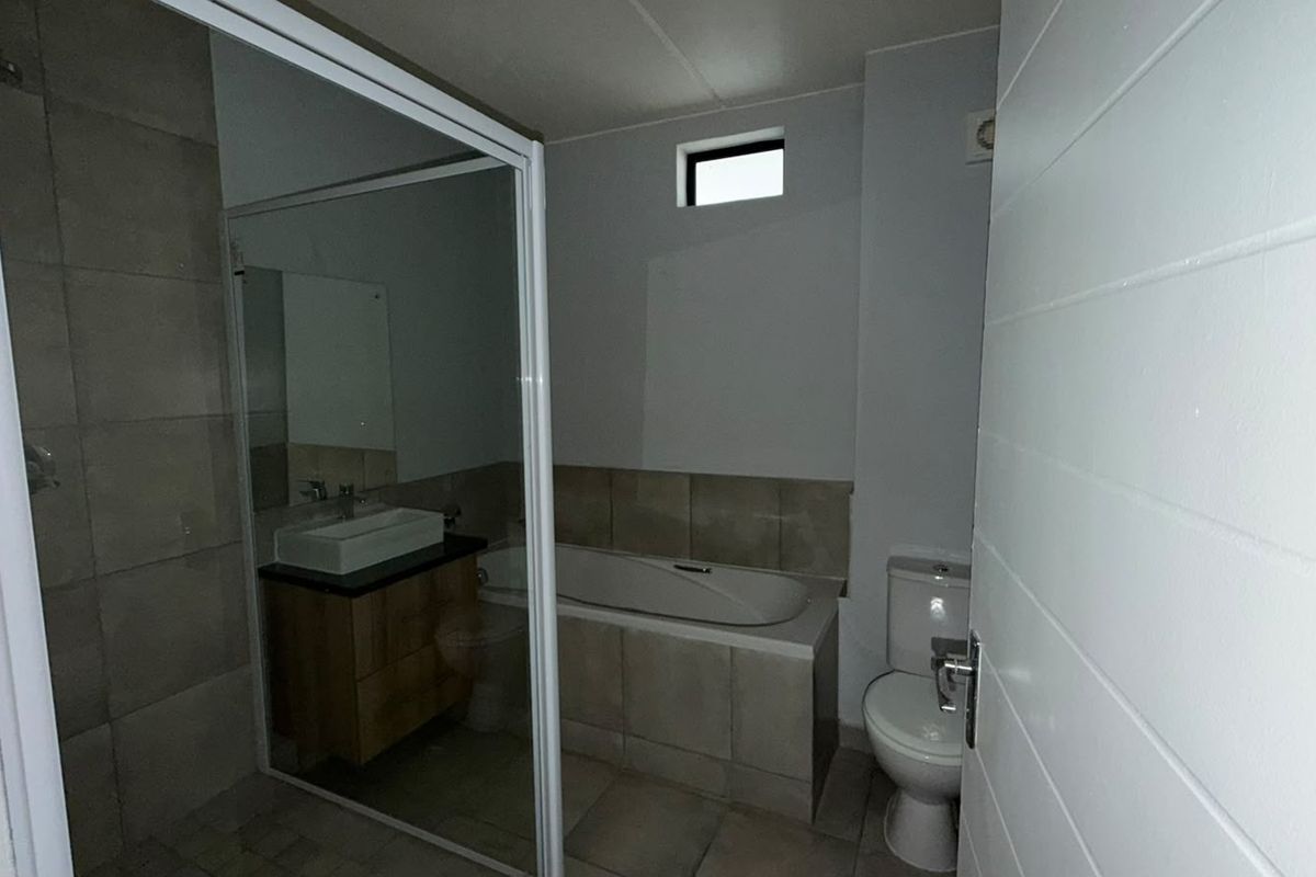 A clean, modern bathroom featuring a built-in vanity with a vessel sink, a bathtub, a separate shower enclosure, and a toilet.