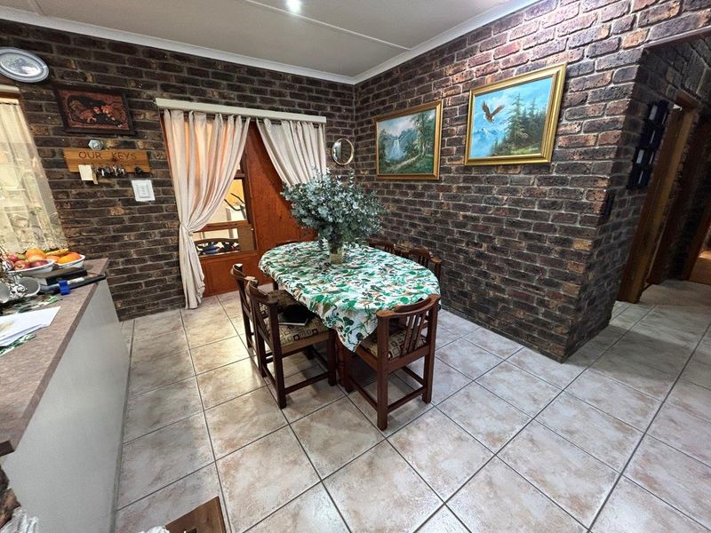 Dining area featuring rustic exposed brick walls and neutral ceramic floor tiles, providing a warm and traditional atmosphere.