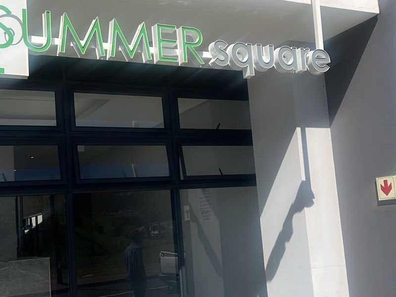 Front entrance view of the Summer Square apartment building featuring modern glass storefront and clean architectural lines.