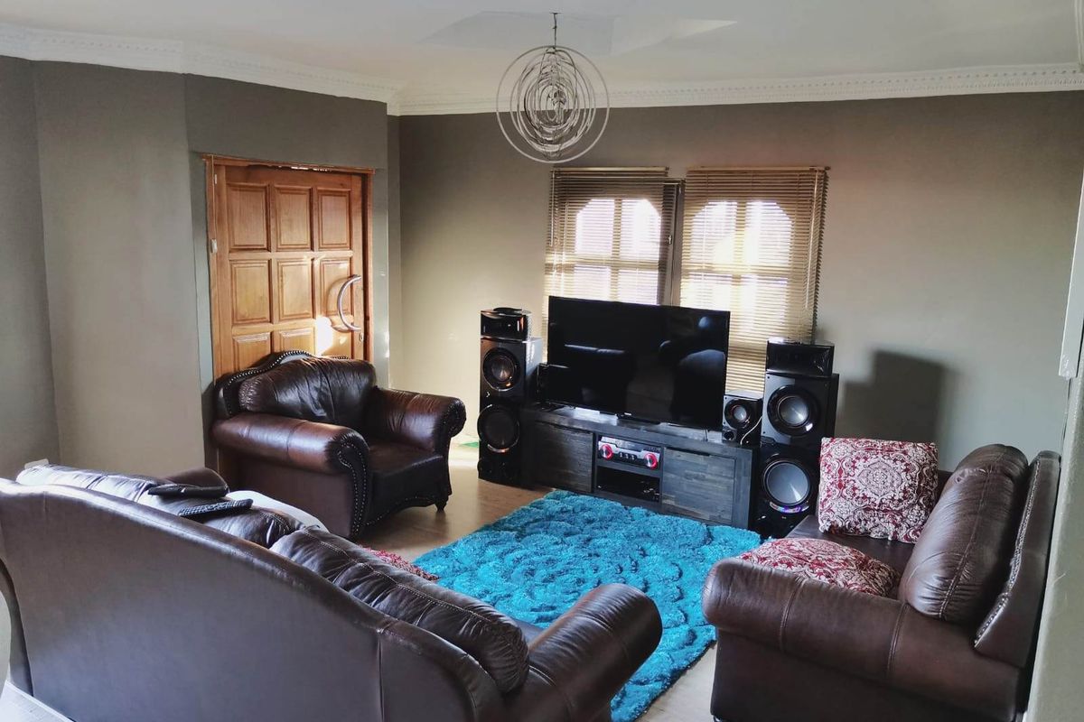 A comfortable living room featuring crown molding, a solid wooden door, and venetian blinds, providing a functional and inviting space for relaxation.