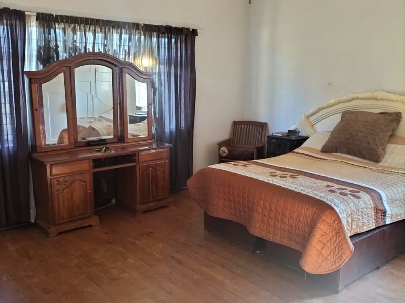 A bedroom featuring original timber flooring and a ventilation grille, requiring cosmetic updates to improve the overall finish and appeal.