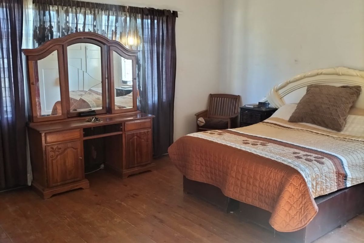 A bedroom featuring original timber flooring and a ventilation grille, requiring cosmetic updates to improve the overall finish and appeal.