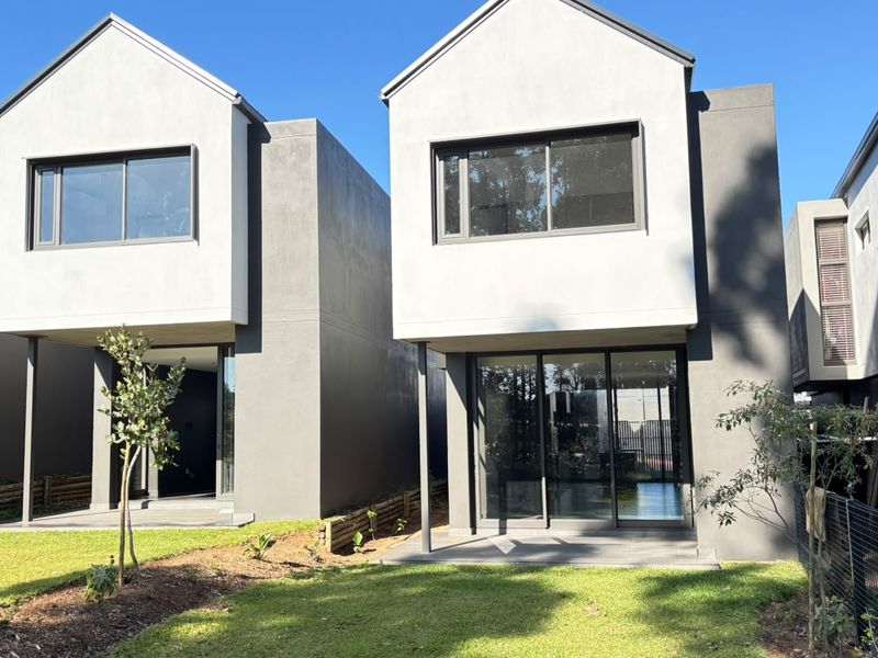 Modern double-storey residential units featuring clean architectural lines, large sliding glass doors, and private ground-floor patios overlooking a landscaped garden area.