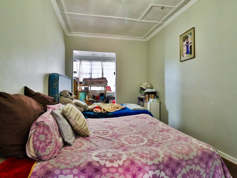 A bedroom featuring traditional ceiling detailing and timber flooring, requiring cosmetic updates to improve the overall finish and appeal.