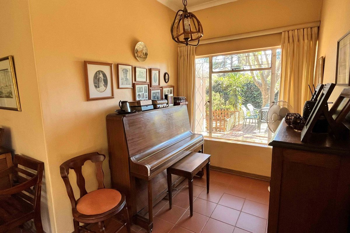 A cozy living area featuring tiled flooring, a large window with natural light, and direct access to an outdoor patio space.