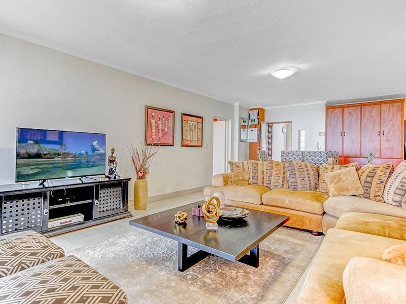 Spacious open-plan living area featuring tiled flooring and built-in cabinetry, providing a functional layout for relaxation and dining.