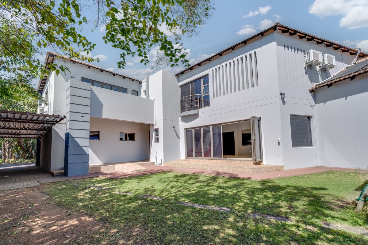 Rear view of the property featuring a paved patio, sliding glass doors, a balcony, and an attached carport area.
