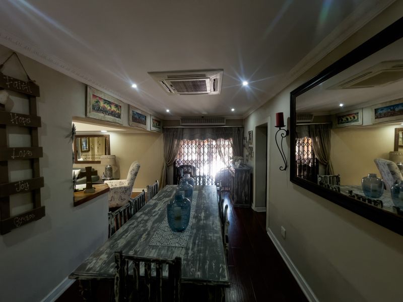 A formal dining room featuring hardwood flooring, recessed ceiling lighting, a built-in air conditioning unit, and decorative crown molding.