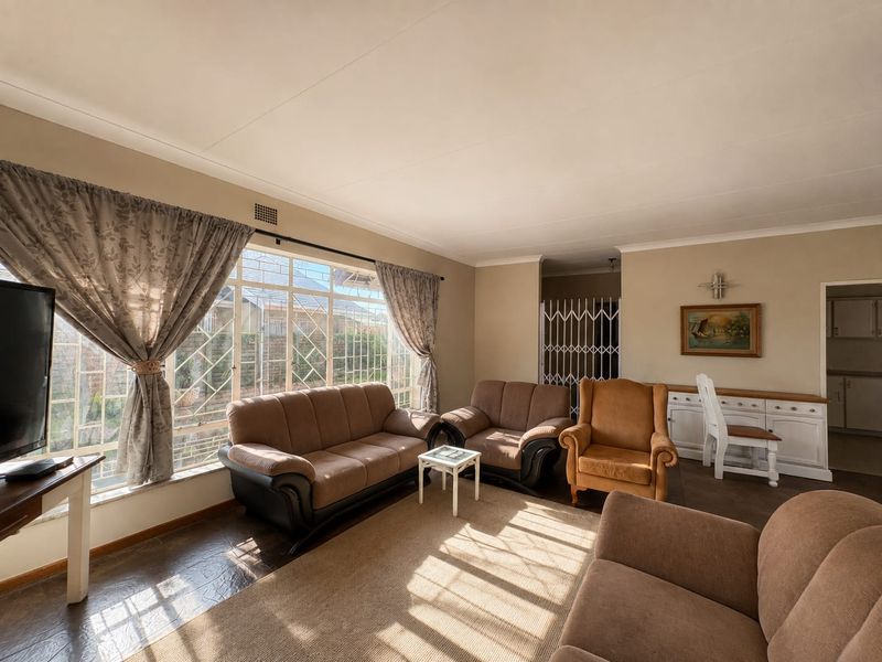 A spacious living room featuring large windows, neutral wall tones, and built-in cabinetry, offering a comfortable and functional living space.