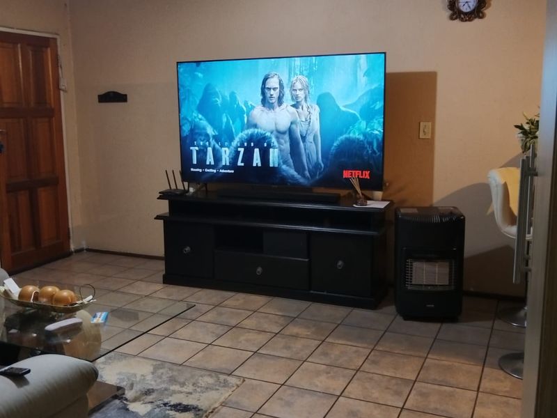 A living room featuring tiled flooring and a textured ceiling, providing a functional space for relaxation and entertainment.