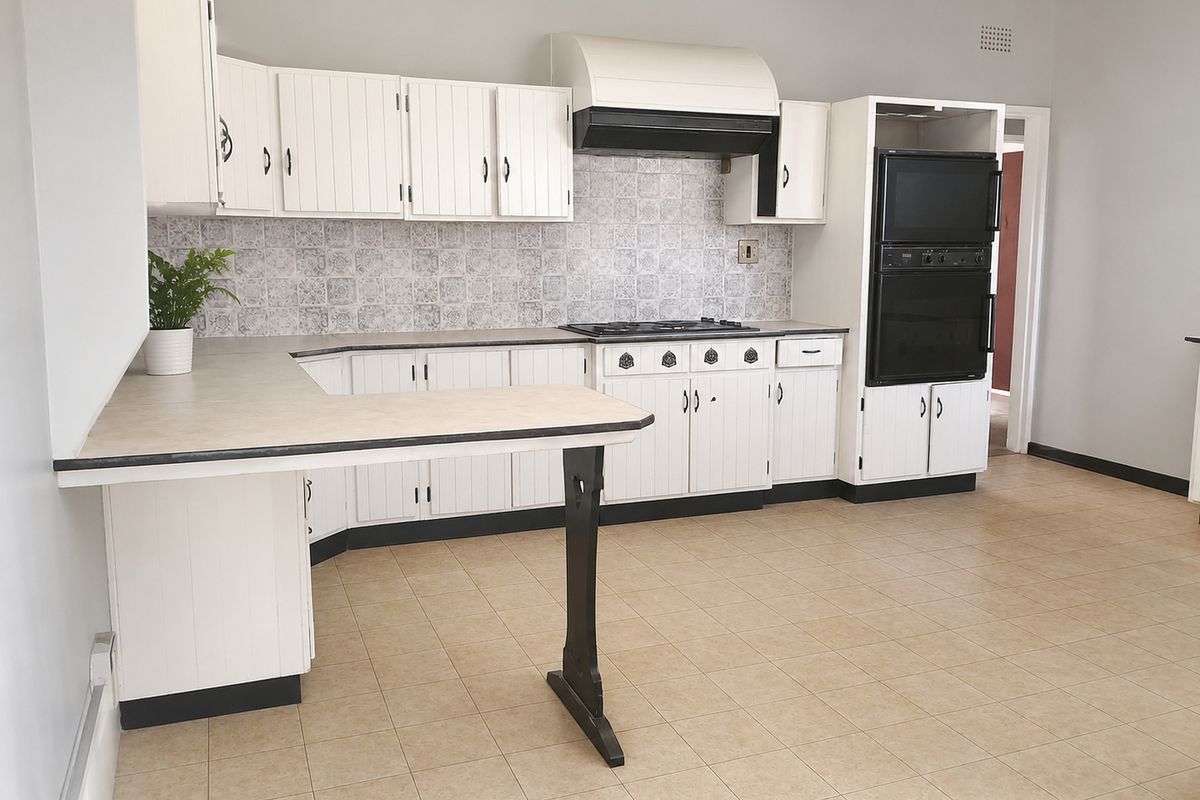 A functional kitchen featuring white cabinetry, a gas hob, built-in oven, and tiled backsplash, offering a clean and practical layout.
