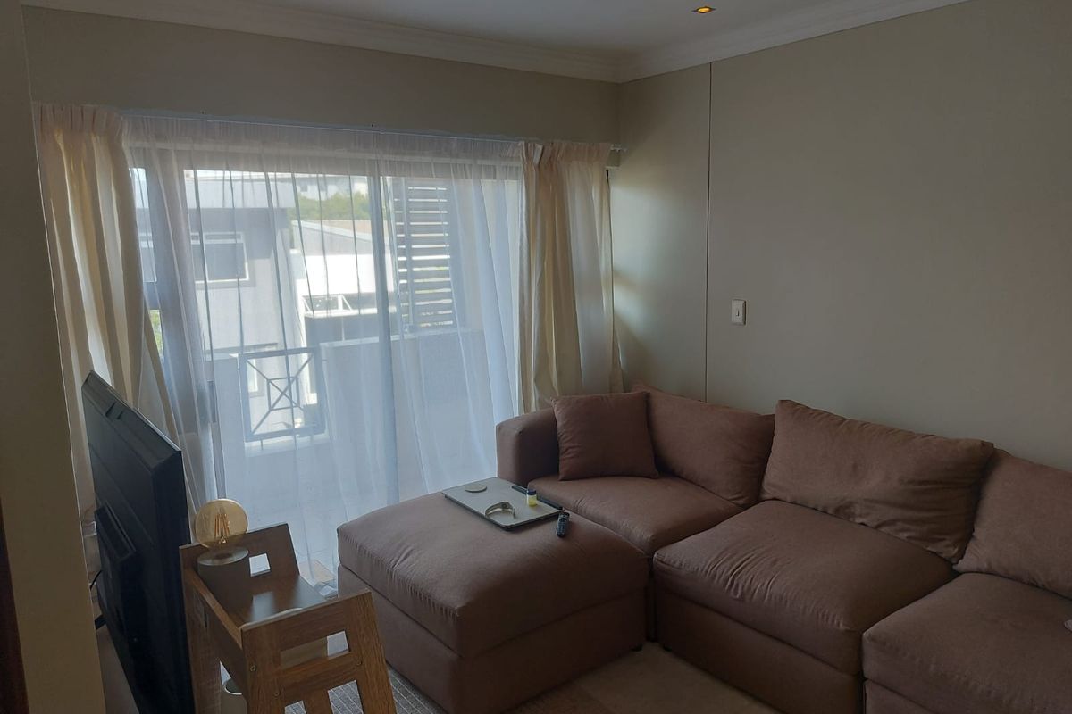 A living room featuring recessed downlights, coving, and a sliding glass door providing access to an outdoor area.
