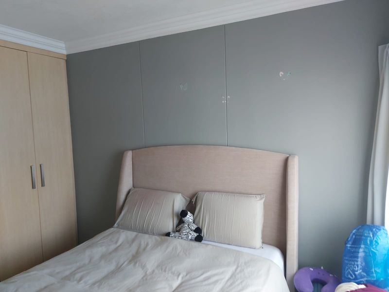 A bedroom featuring a built-in wardrobe and crown molding, with neutral wall tones and a standard layout.