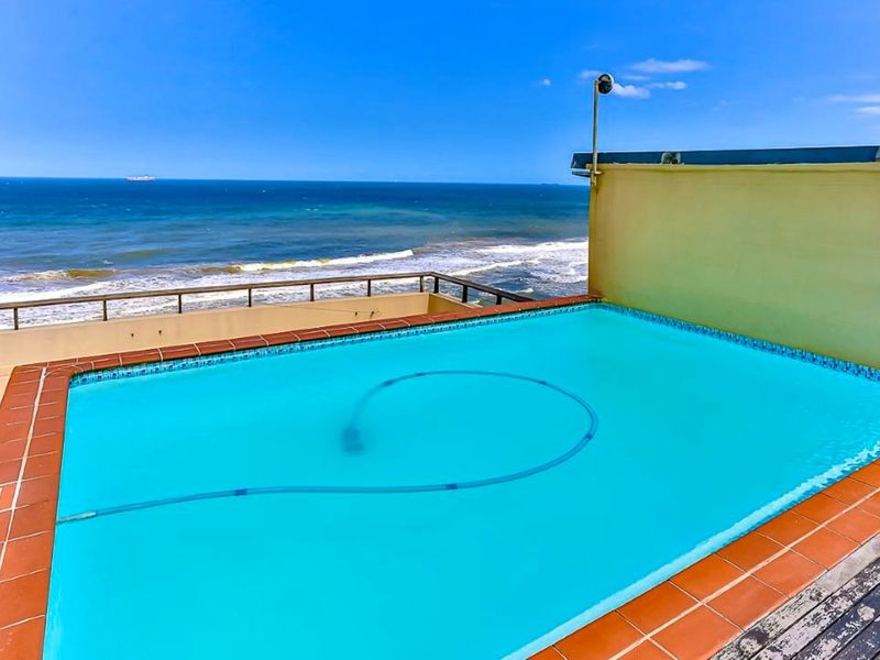 An elevated swimming pool area featuring a metal balustrade and expansive ocean views, providing a private outdoor space for relaxation.