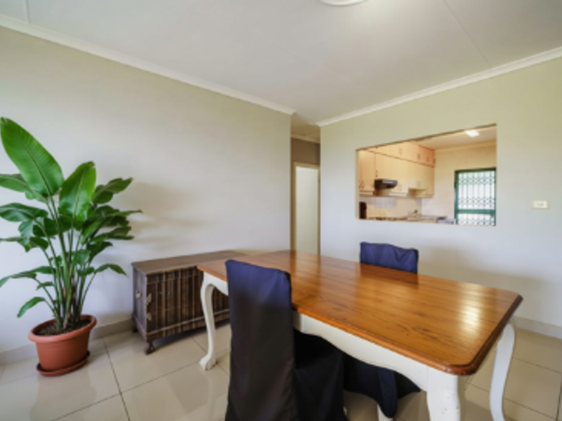 Dining area featuring tiled flooring and a convenient pass-through window connecting to the kitchen space.