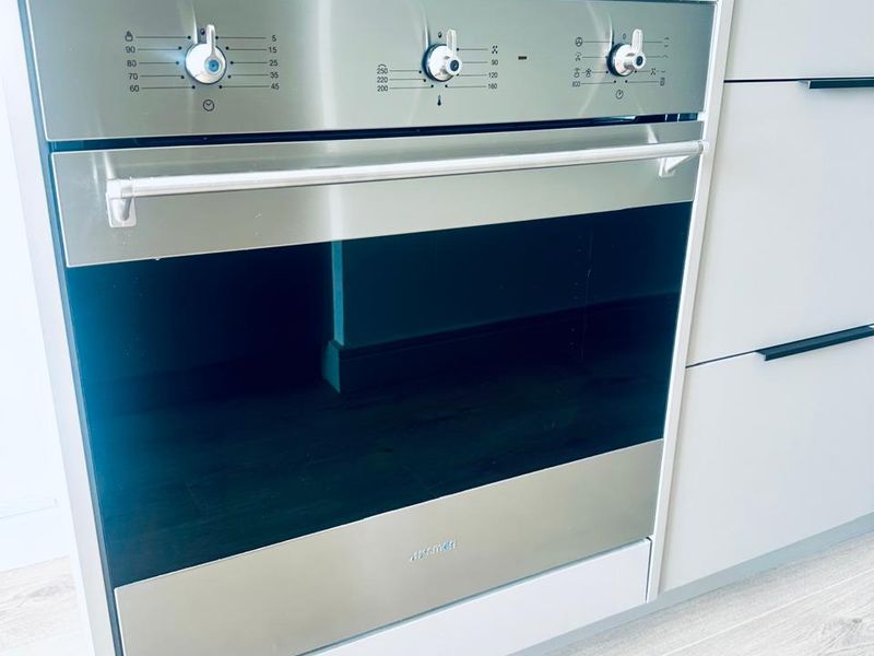 A modern kitchen featuring a built-in stainless steel oven, sleek cabinetry, and a clean, contemporary finish.