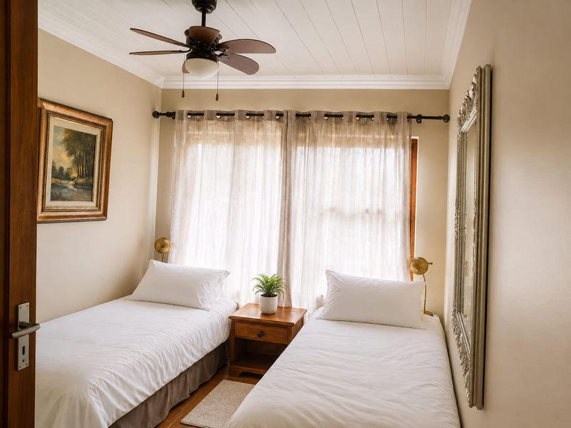 A cozy bedroom featuring a tongue and groove ceiling, ceiling fan, and large window with curtain rod.