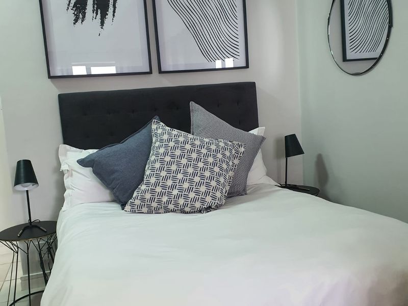 A well-presented bedroom featuring neutral wall finishes and tiled flooring, creating a clean and comfortable living space.