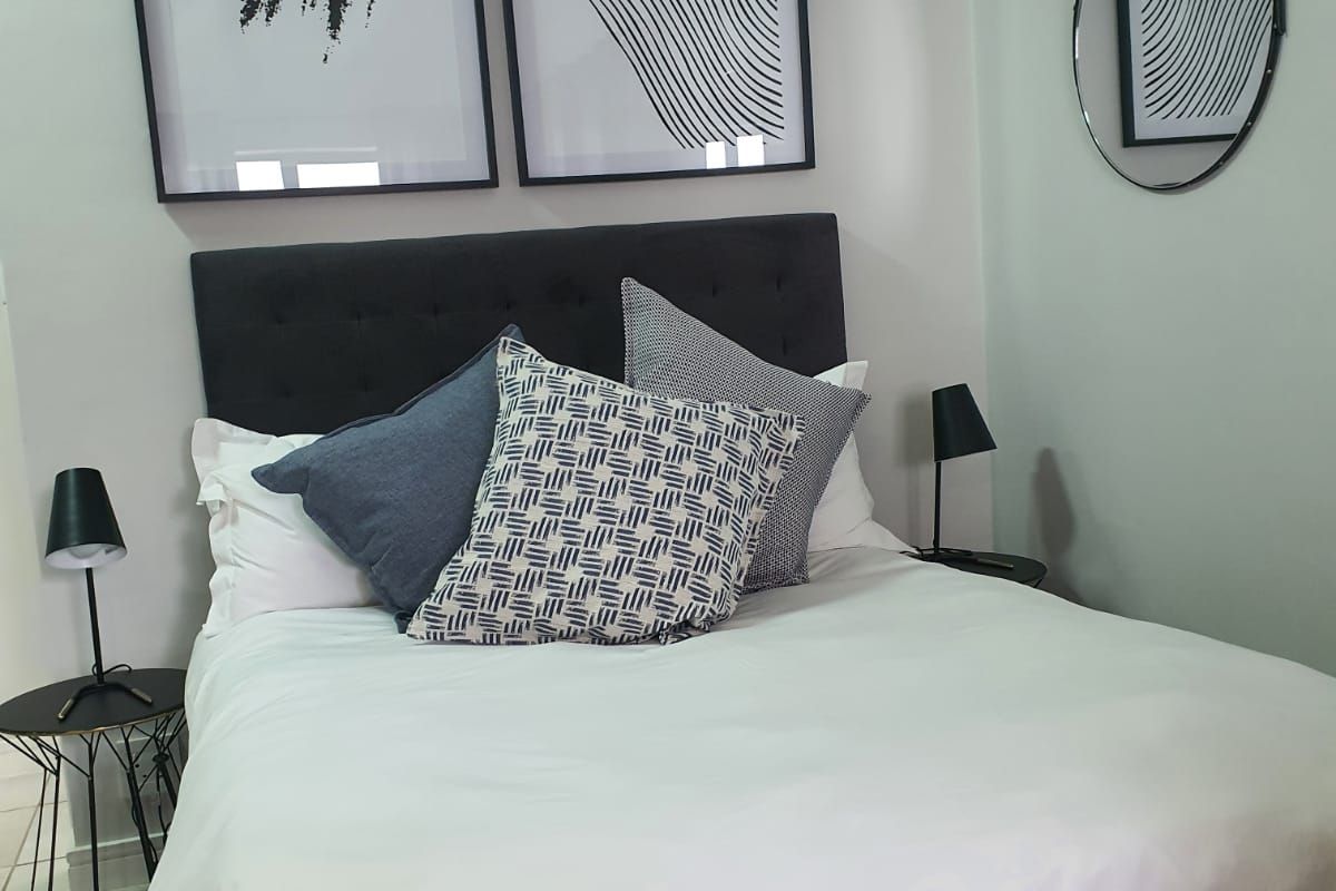 A well-presented bedroom featuring neutral wall finishes and tiled flooring, creating a clean and comfortable living space.