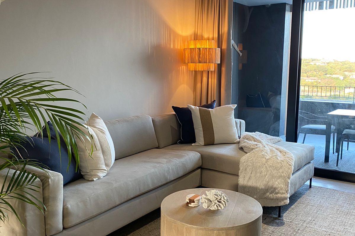Modern living room featuring a staircase, recessed lighting, and large sliding glass doors that open onto a balcony with scenic views.