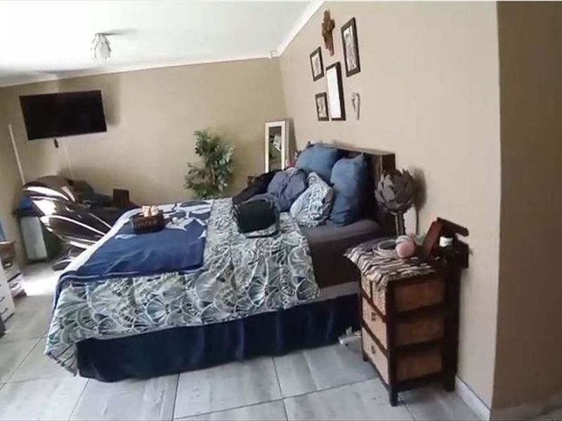 A bedroom featuring tiled flooring and coved ceilings, providing a functional space with neutral wall tones.