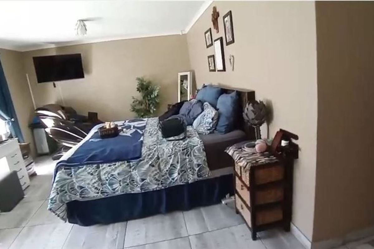 A bedroom featuring tiled flooring and coved ceilings, providing a functional space with neutral wall tones.