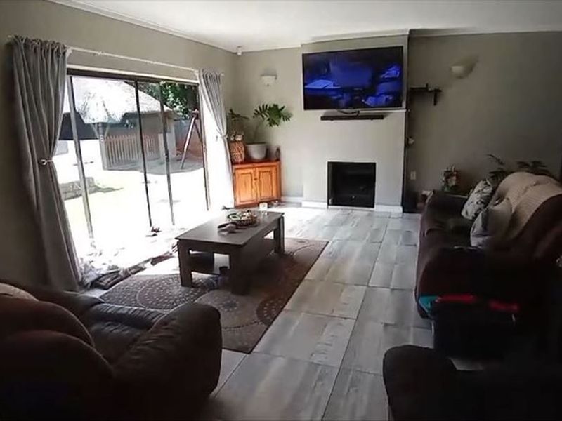 Spacious living room featuring tiled flooring, a built-in fireplace, and large sliding glass doors providing direct access to the outdoor area.