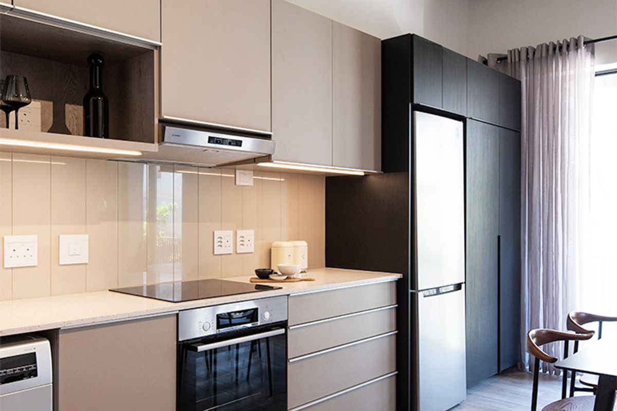 Modern kitchen featuring sleek cabinetry, stone countertops, integrated appliances, and a striking exposed concrete ceiling, creating a contemporary and functional living space.
