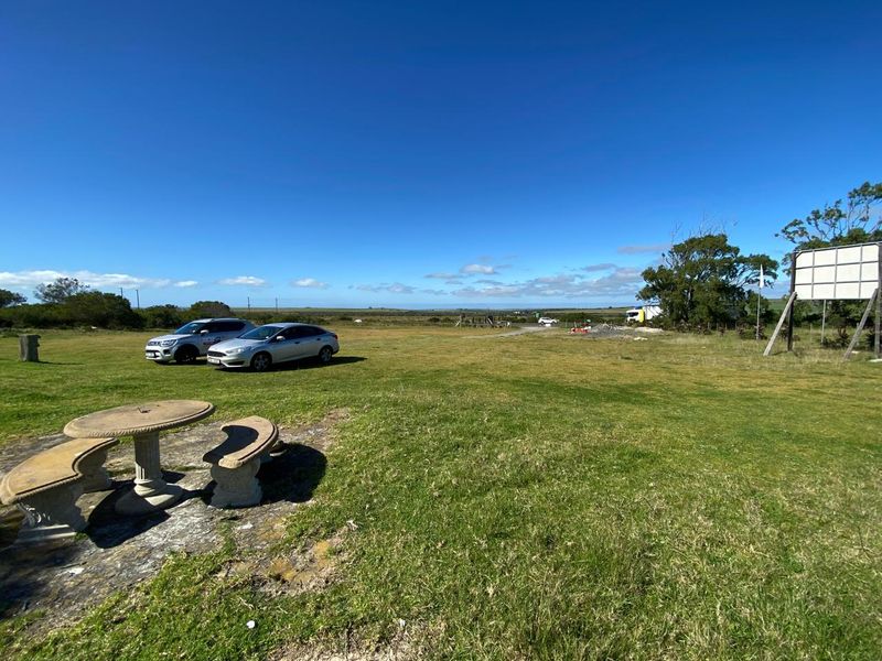 Expansive open landscape view featuring a large billboard structure on the property grounds under a clear blue sky.