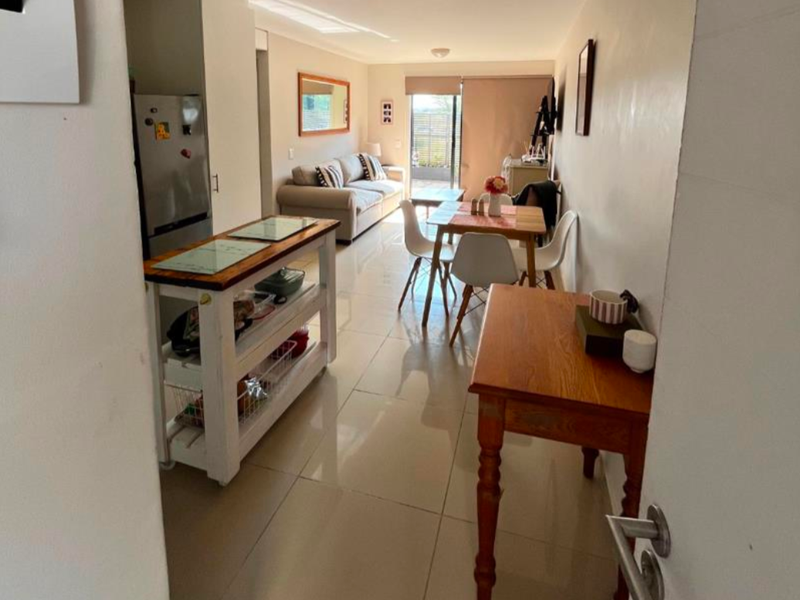 An open-plan living and dining area featuring polished tiled flooring and a sliding glass door leading to an outdoor space.
