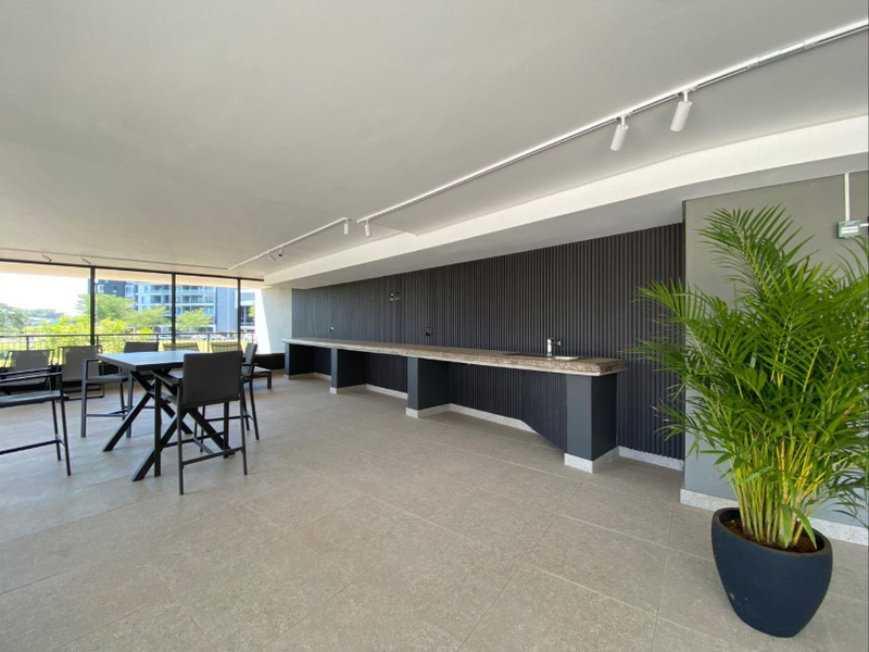 Spacious covered balcony featuring a modern built-in counter with sink, stylish slatted wall paneling, and contemporary track lighting.