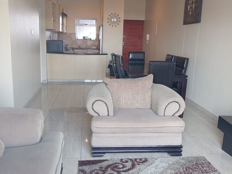 Open plan living and dining area featuring tiled flooring, recessed lighting, and a functional kitchen with built-in cabinetry and countertops.