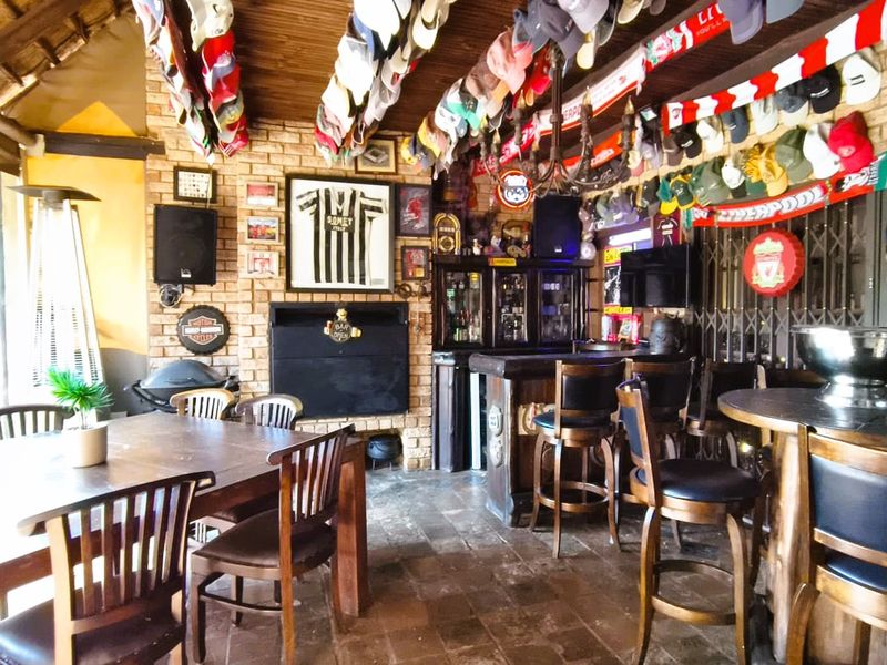 A rustic entertainment area featuring a built-in bar, brick wall detailing, and a thatched roof, providing a cozy space for social gatherings.