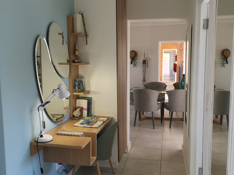 A well-maintained hallway featuring tiled flooring, a built-in desk unit, and integrated cabinetry, providing a functional transition space between rooms.