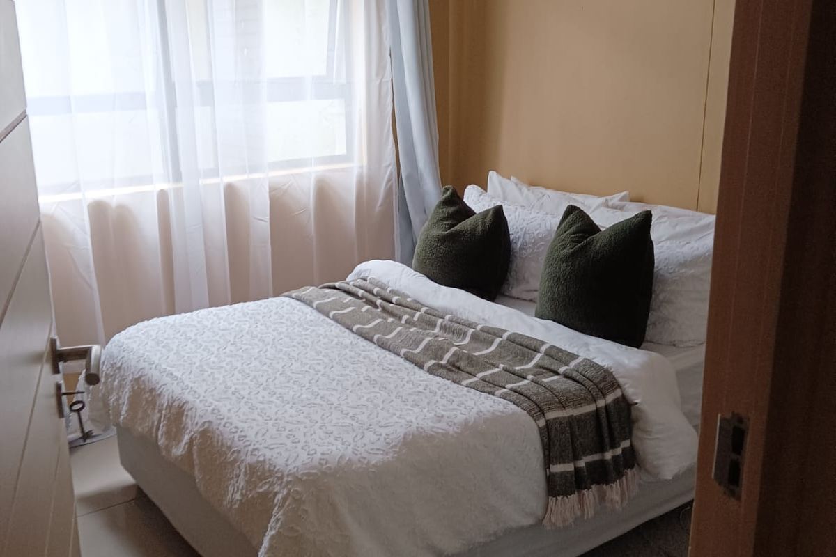 A compact bedroom featuring tiled flooring and a window with natural light, providing a functional space for rest.