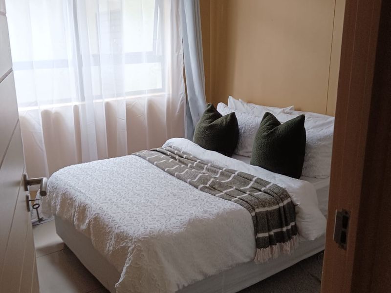 A compact bedroom featuring tiled flooring and a window with natural light, providing a functional space for rest.