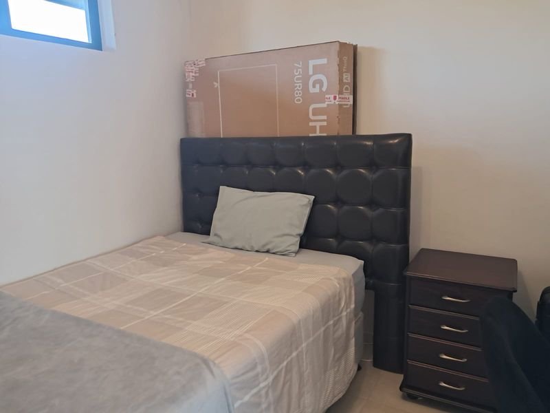 A standard bedroom featuring neutral wall finishes and a high-level window, providing a functional space for rest.