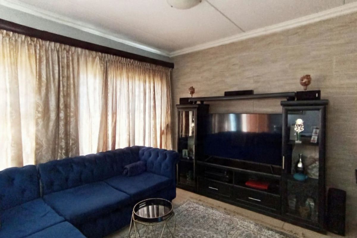 A living room featuring textured wall cladding and decorative coving, providing a neutral base for interior updates.