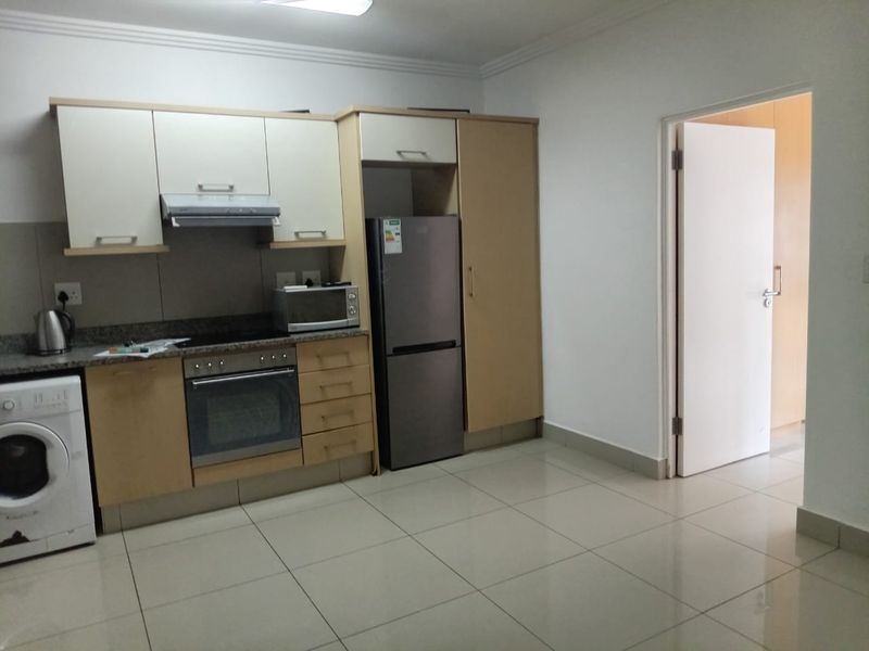 A functional kitchen featuring built-in cabinetry, granite countertops, an integrated oven, and tiled flooring, offering a clean and practical layout.