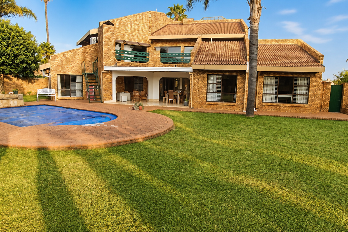 Spacious rear exterior featuring a brick-faced house, a swimming pool with cover, a covered patio, and a well-maintained lawn.